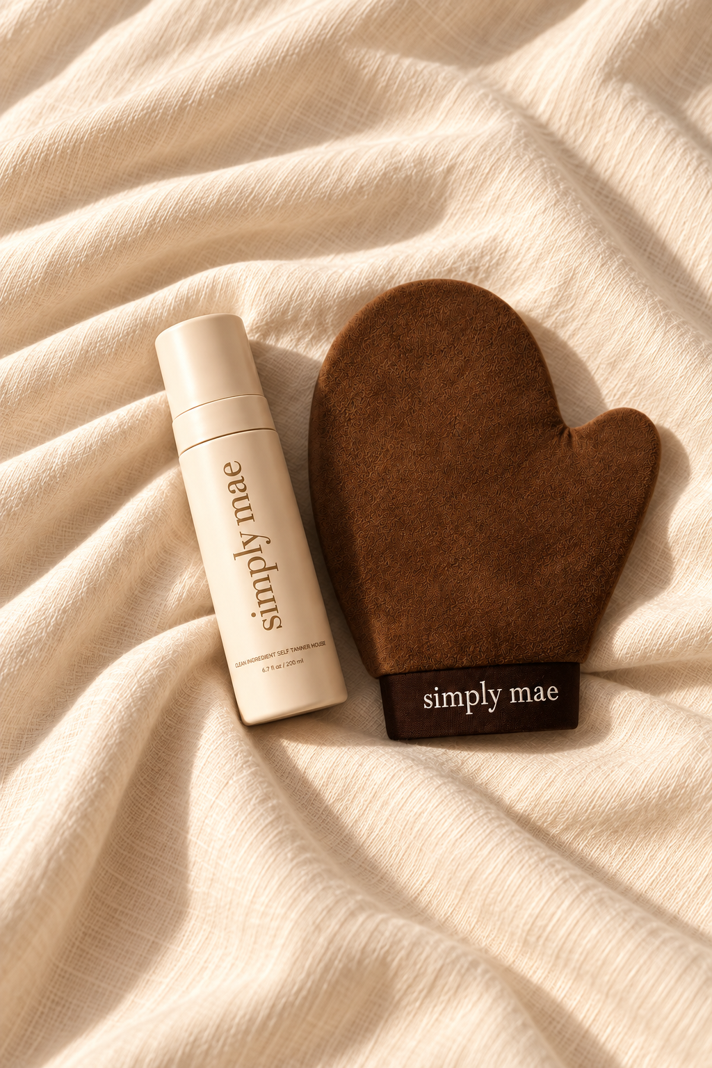 Hands holding Simply Mae mousse and application mitt in a sunlit bathroom